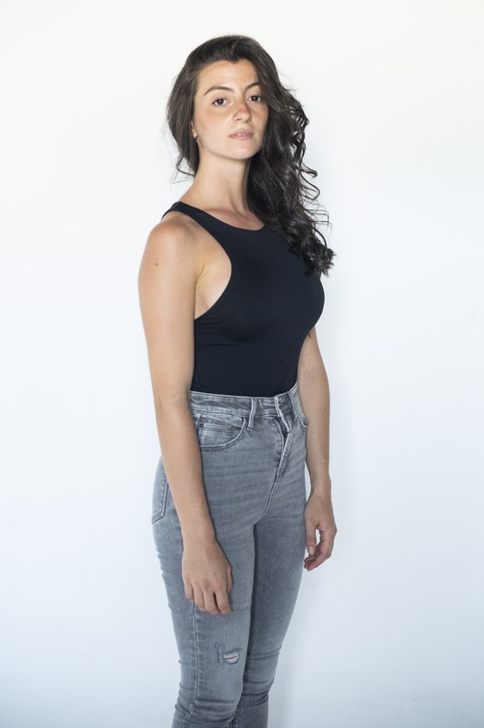 Carmen Tur de pie, top negro y vaqueros, fondo blanco