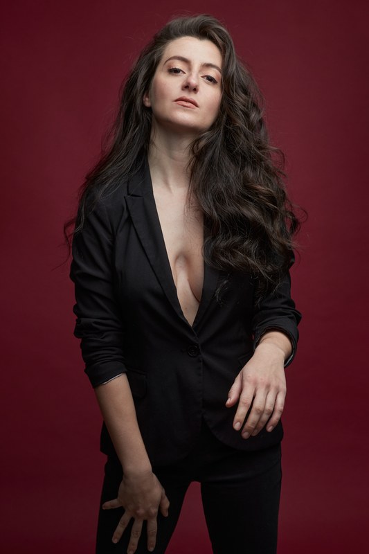Carmen Tur con blazer negra, fondo rojo
