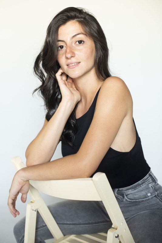 Carmen Tur sentada, top negro, fondo blanco