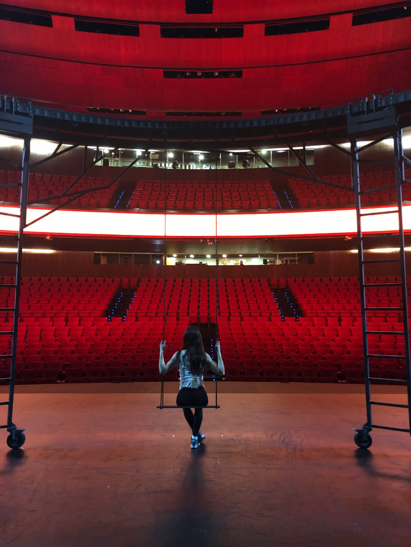 Carmen Tur en un columpio sobre el escenario de un teatro vacío