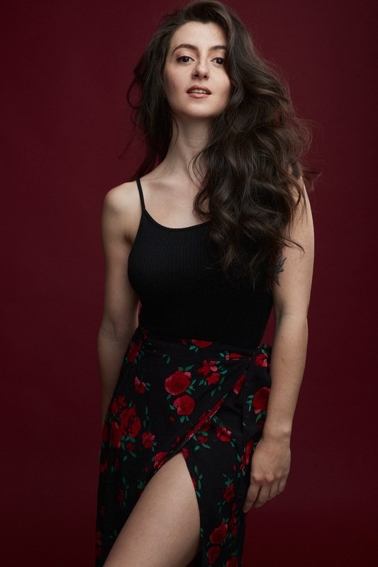 Carmen Tur, top negro y falda de flores, fondo rojo
